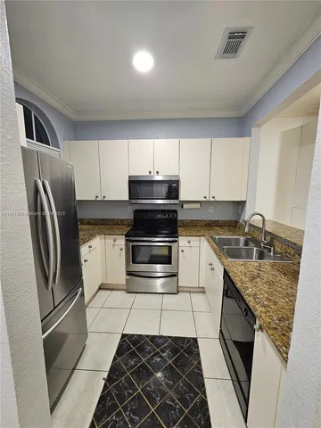a kitchen with a refrigerator sink and cabinets
