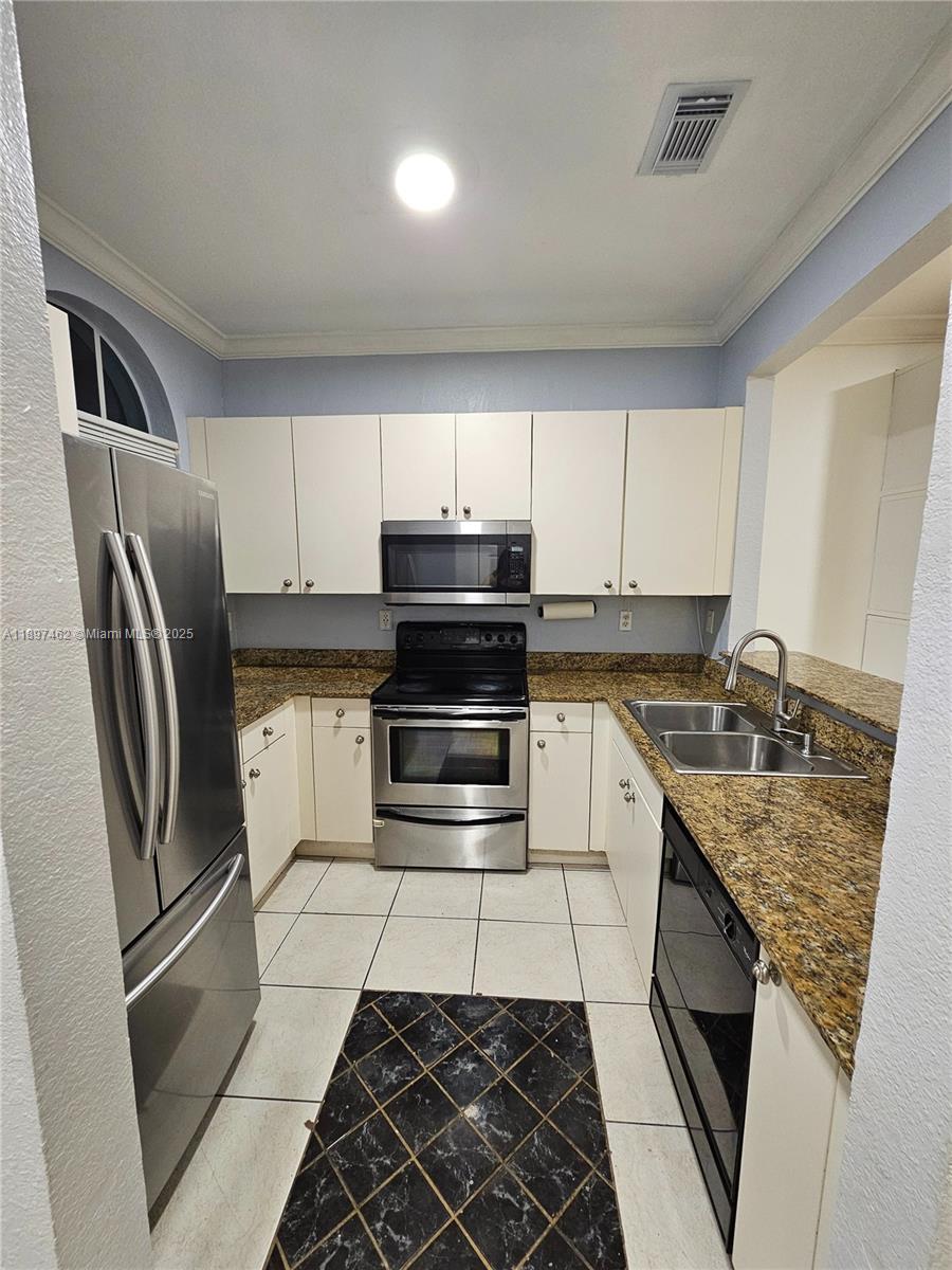 12708 Southwest 49th Drive, Unit 12708 Miramar, FL 33027 - Photo 8 of 14 a kitchen with a refrigerator sink and cabinets