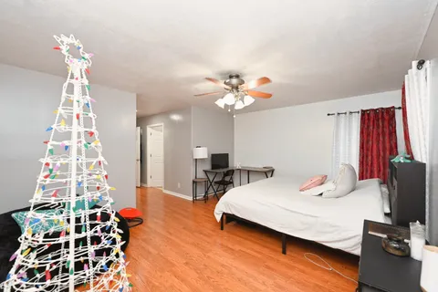 a bedroom with a bed and wooden floor