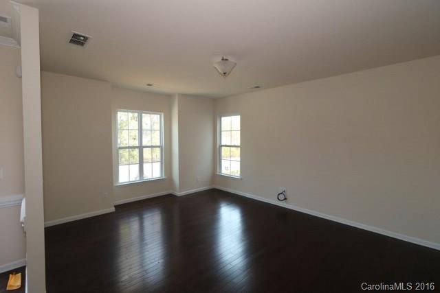 5165 Waterloo Drive, Unit CC153 Tega Cay, SC 29708 - Photo 6 of 6 an empty room with wooden floor and windows with curtains