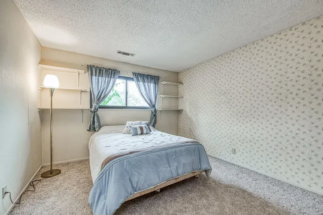 an empty room with a window and a ceiling fan