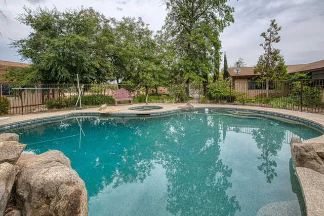 a view of a yard with plants and wooden fence