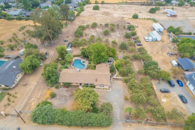 an aerial view of a house with a yard and greenery