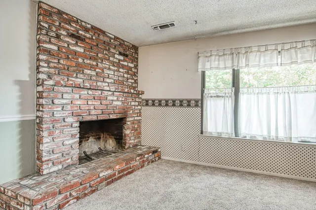 a living room with a fireplace and a window