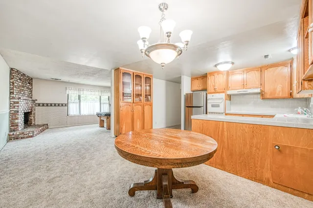 a view of a kitchen with granite countertop a sink window and a refrigerator