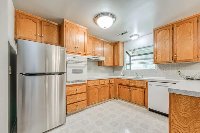 a kitchen with stainless steel appliances granite countertop a refrigerator sink and cabinets