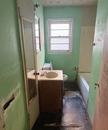 a bathroom with sink toilet and window