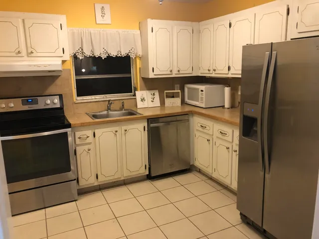 a kitchen with stainless steel appliances granite countertop a refrigerator sink and cabinets