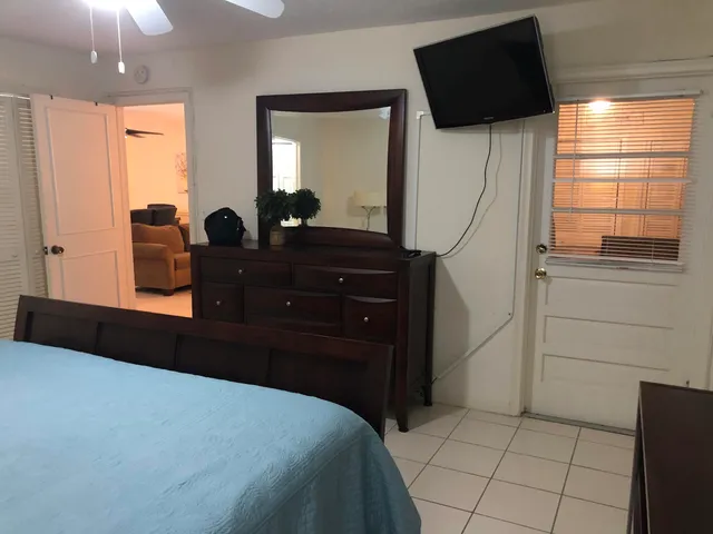 a room with a bed a flat screen tv and a dresser
