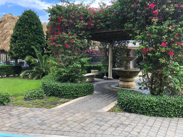 a view of a pathway with flower plants