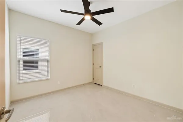 an empty room with a window and a fan
