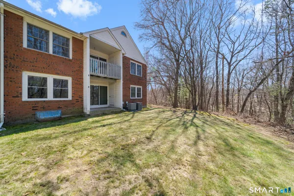 a view of a brick house with many windows next to a yard