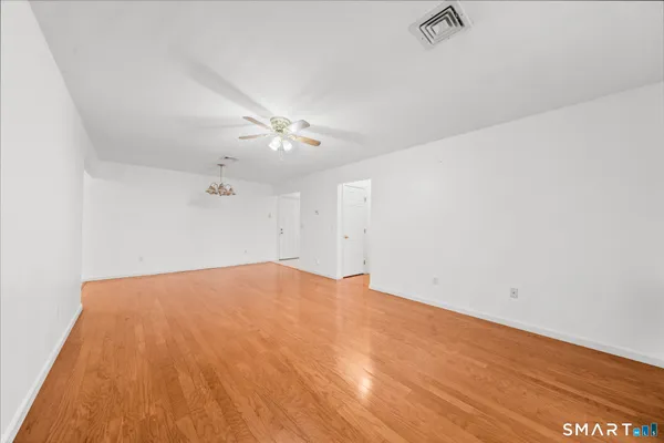 a view of empty room with wooden floor