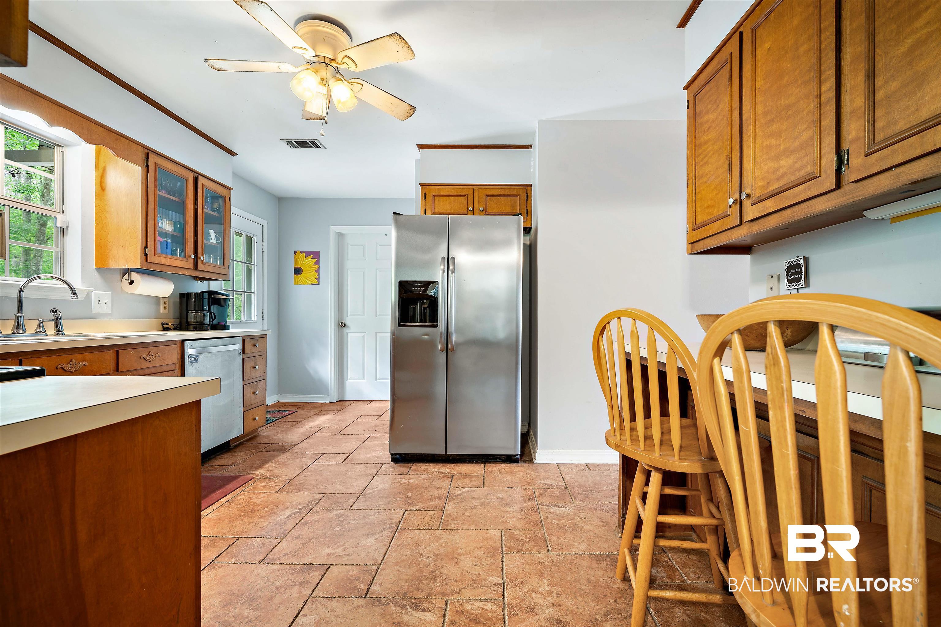 2823 Woodland Road Mobile, AL 36693 - Photo 5 of 29 Kitchen with stainless steel appliances, light countertops, visible vents, a sink, and brown cabinetry