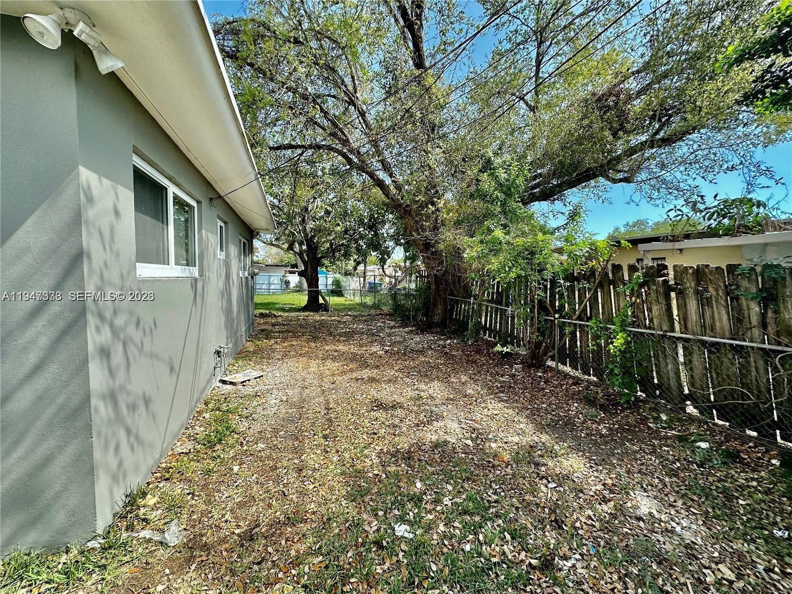 1894 Northwest 53rd Street Miami, FL 33142 - Photo 12 of 19 a view of a yard with plants and a bench