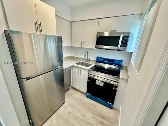 a kitchen with stainless steel appliances a refrigerator a stove a microwave and cabinets