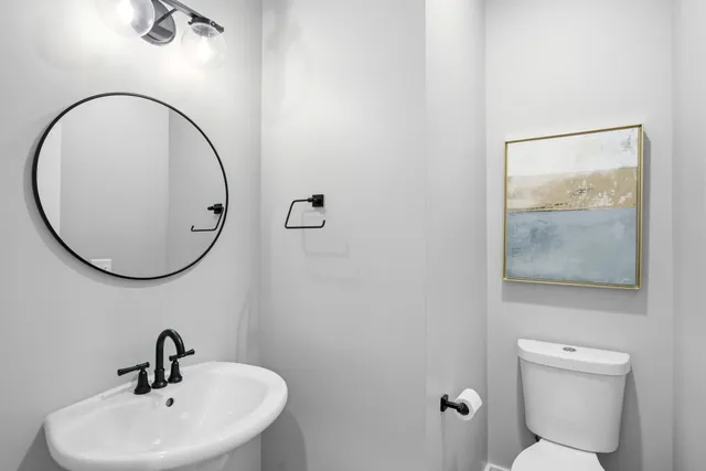 a bathroom with a toilet a sink and mirror