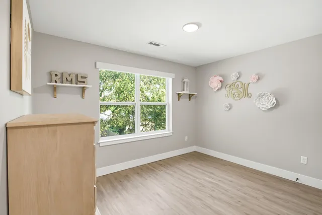 an empty room with a window and a ceiling fan
