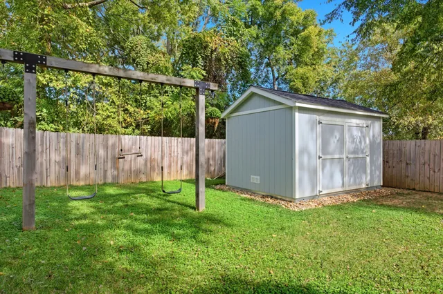 a view of backyard with a barbeque grill and a large tree