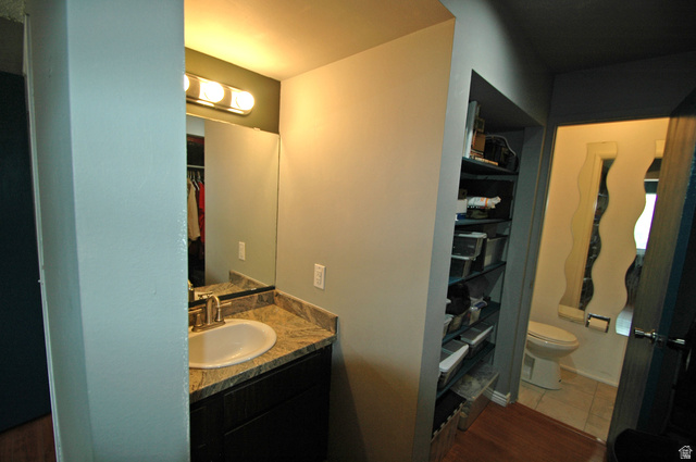 46 Lester Avenue, Unit G 24 Murray, UT 84107 - Photo 13 of 16 Vanity area featuring a built-in cabinet with brushed nickel hardware, an undermount sink, and a granite countertop