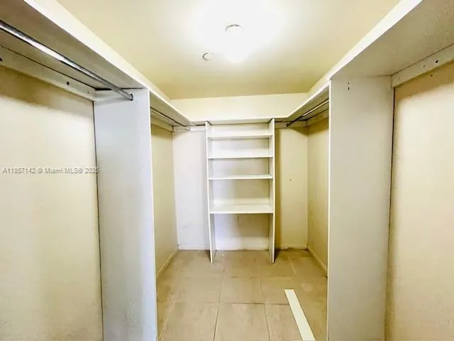 a view of walk in closet with empty racks