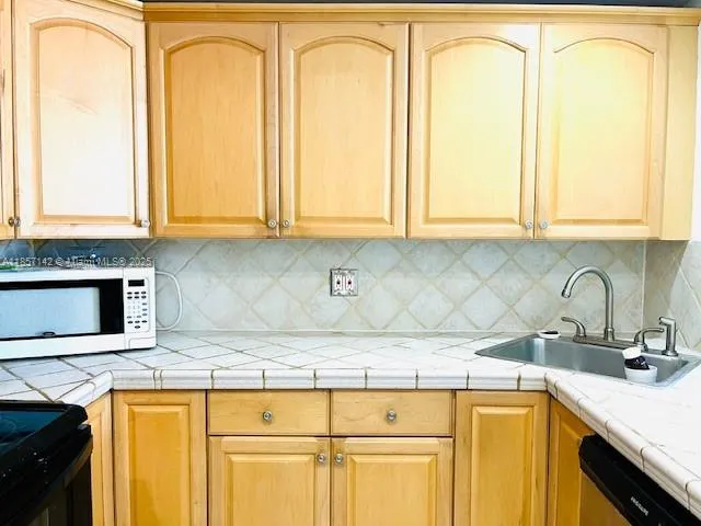 a kitchen with stainless steel appliances granite countertop a sink a stove and cabinets