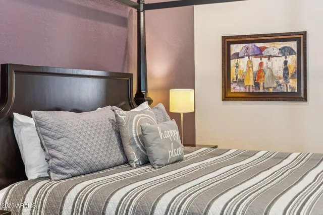 a bedroom with a bed and lamp on dresser