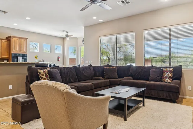 a living room with furniture a large window and a chandelier