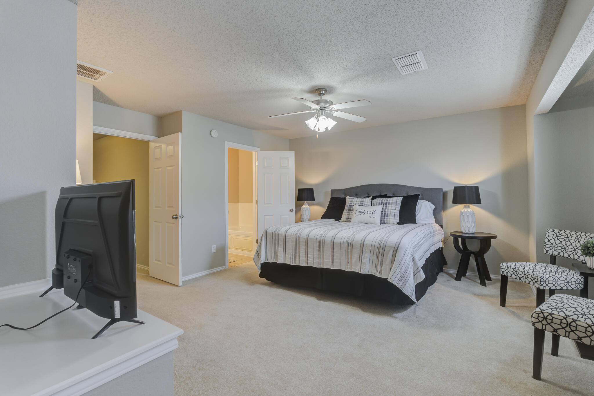 2111 Main Street, Unit 3 Lubbock, TX 79401 - Photo 30 of 49 a bedroom with a bed and a chandelier