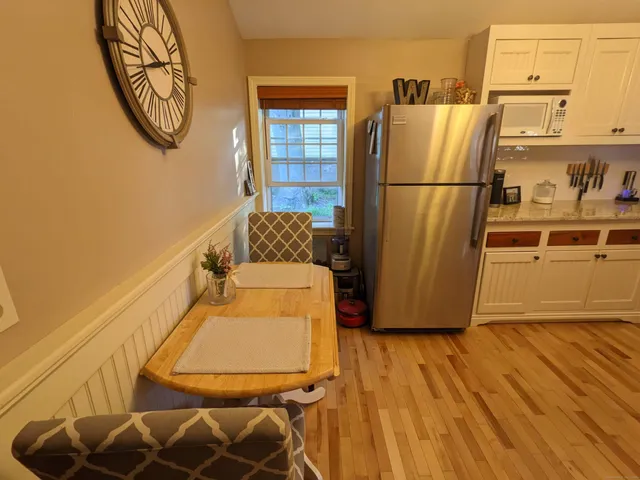 a view of a kitchen with wooden floor and a refrigerator
