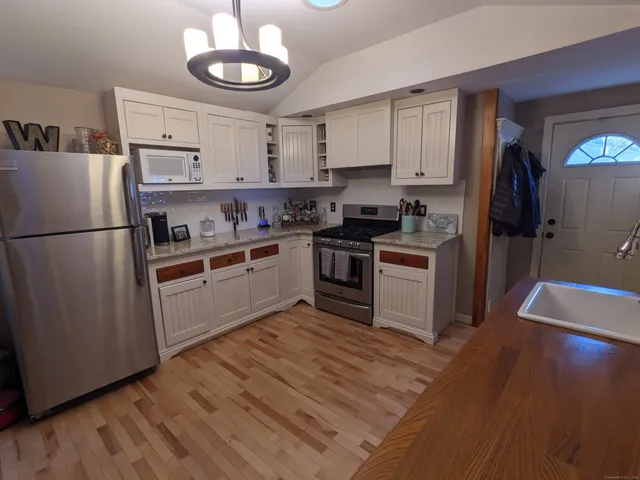 a kitchen with a refrigerator a stove top oven a sink and cabinets