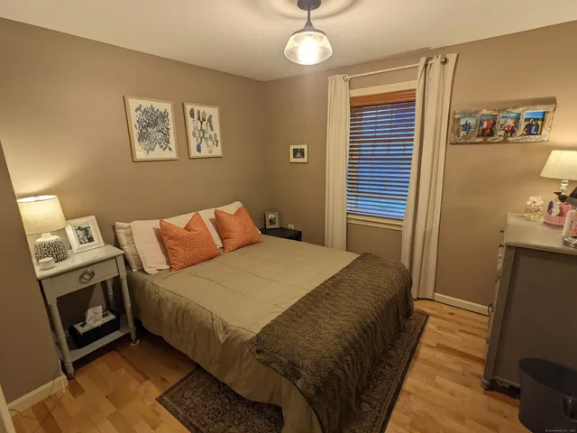 a bedroom with a bed a mirror on the dresser and a chandelier