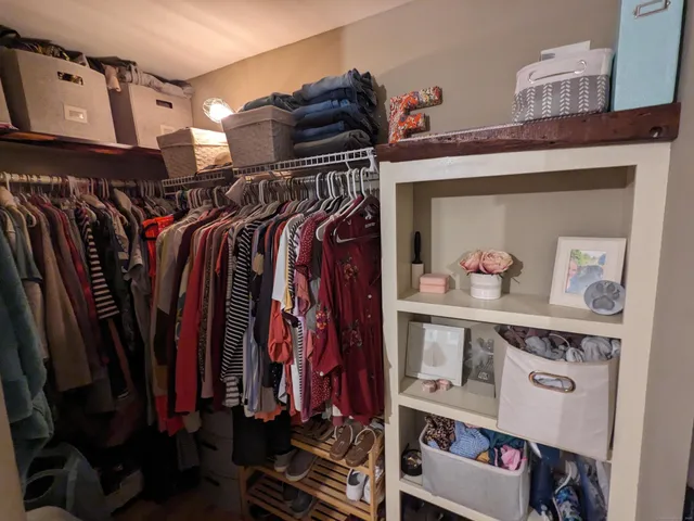 a view of walk in closet with clothes and shoes
