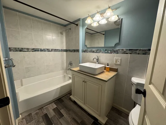 a bathroom with a sink and mirror with bathtub
