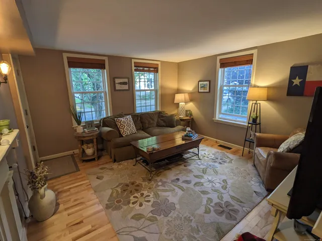 a living room with furniture a rug and a window