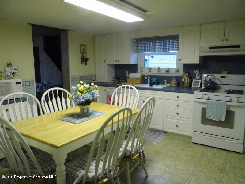 709 Spring Street Moosic, PA 18507 - Photo 2 of 11 a kitchen with a table chairs stove and microwave