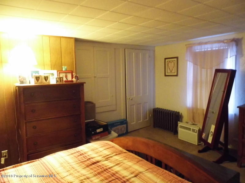 709 Spring Street Moosic, PA 18507 - Photo 9 of 11 a bedroom with a bed and a mirror