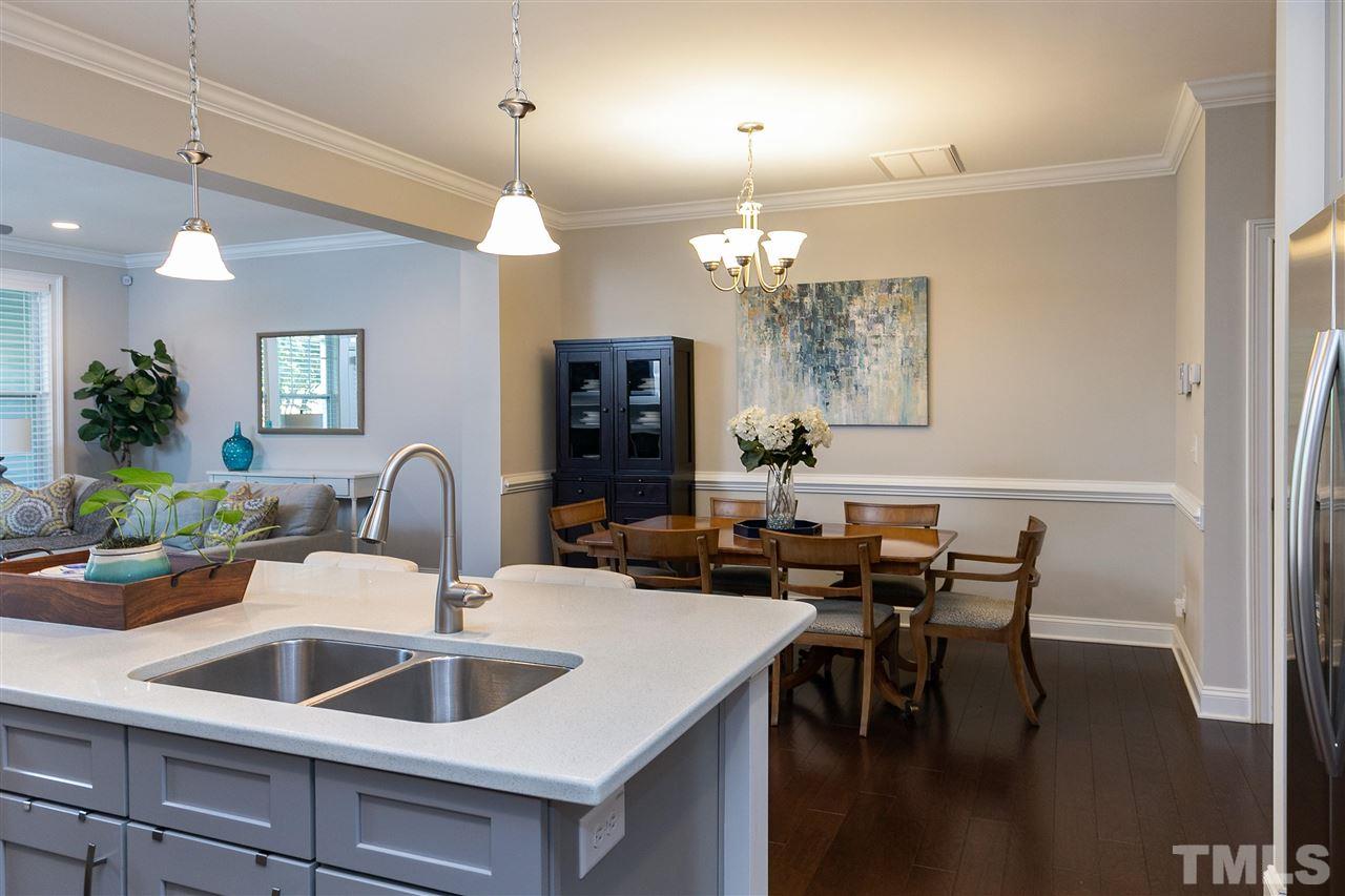 637 Fallon Grove Way Raleigh, NC 27608 - Photo 11 of 30 a kitchen with a dining table chairs sink and kitchen view