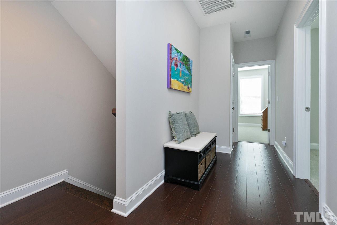 637 Fallon Grove Way Raleigh, NC 27608 - Photo 16 of 30 a view of a hallway to a livingroom with wooden floor and furniture