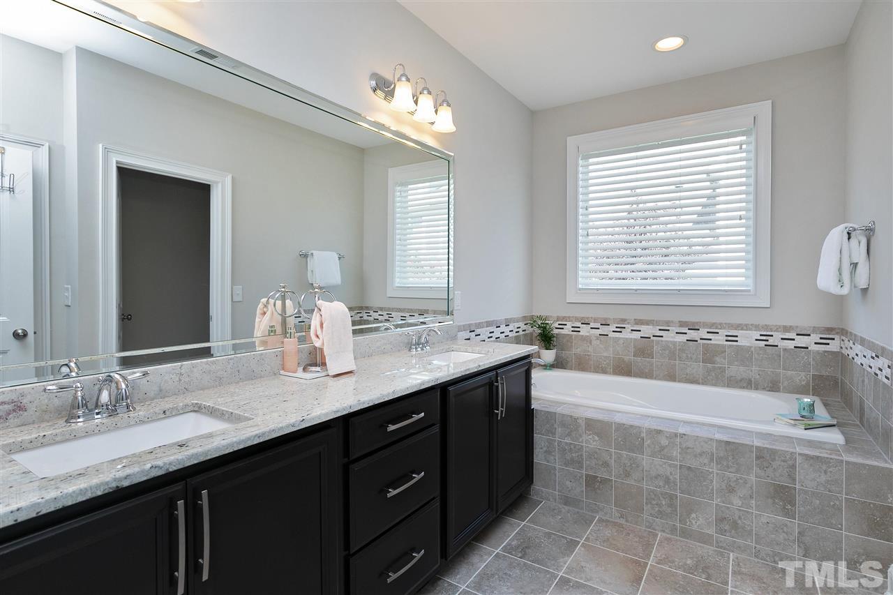 637 Fallon Grove Way Raleigh, NC 27608 - Photo 19 of 30 a bathroom with a granite countertop bathtub sink double and mirror