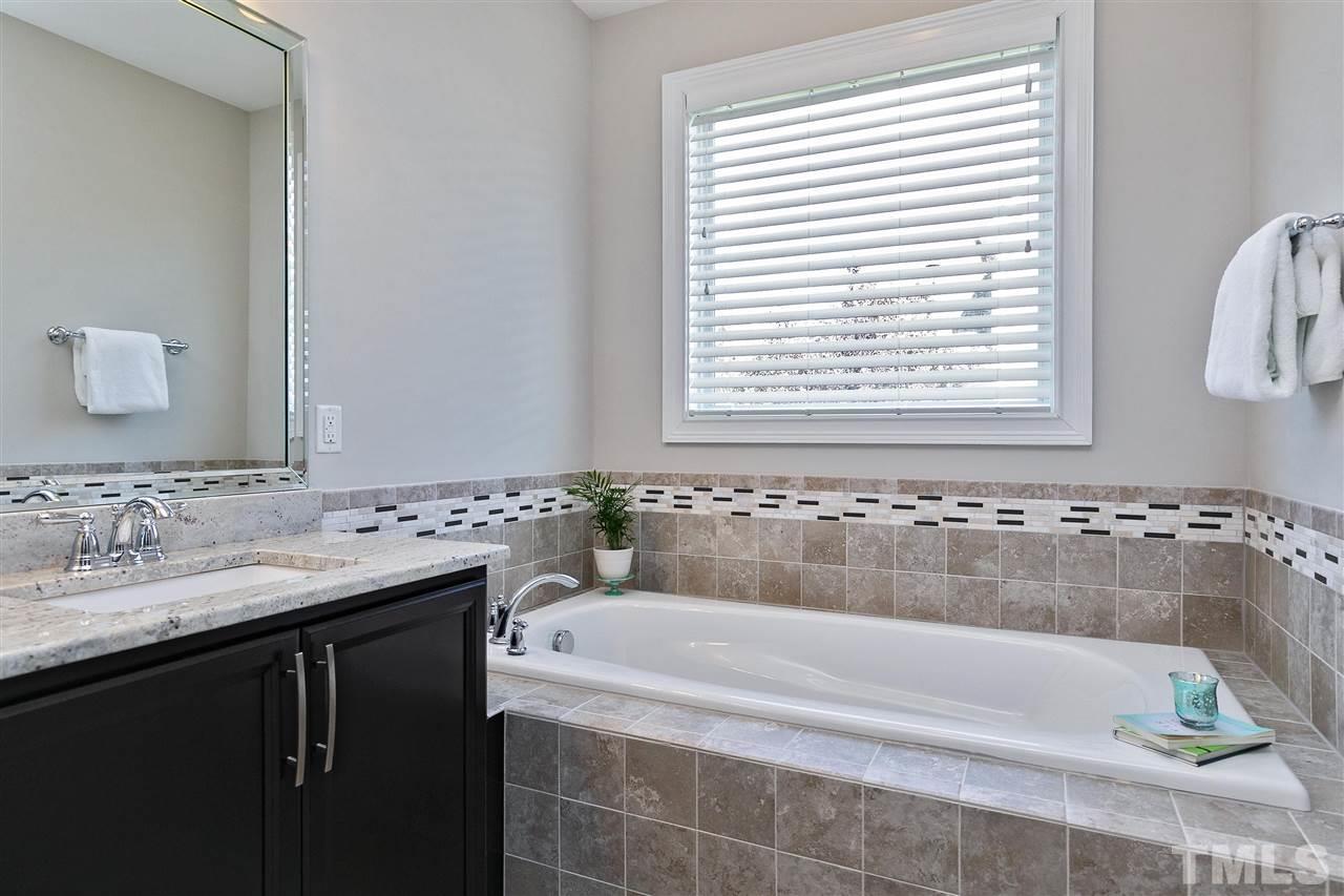 637 Fallon Grove Way Raleigh, NC 27608 - Photo 20 of 30 a bathroom with a bathtub and a sink