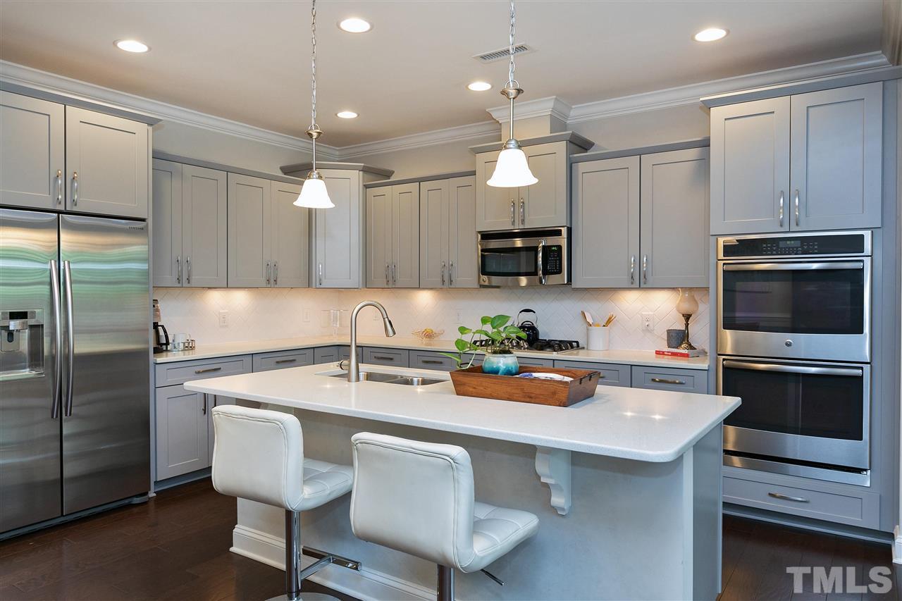 637 Fallon Grove Way Raleigh, NC 27608 - Photo 4 of 30 a kitchen with a sink a microwave a stove and refrigerator
