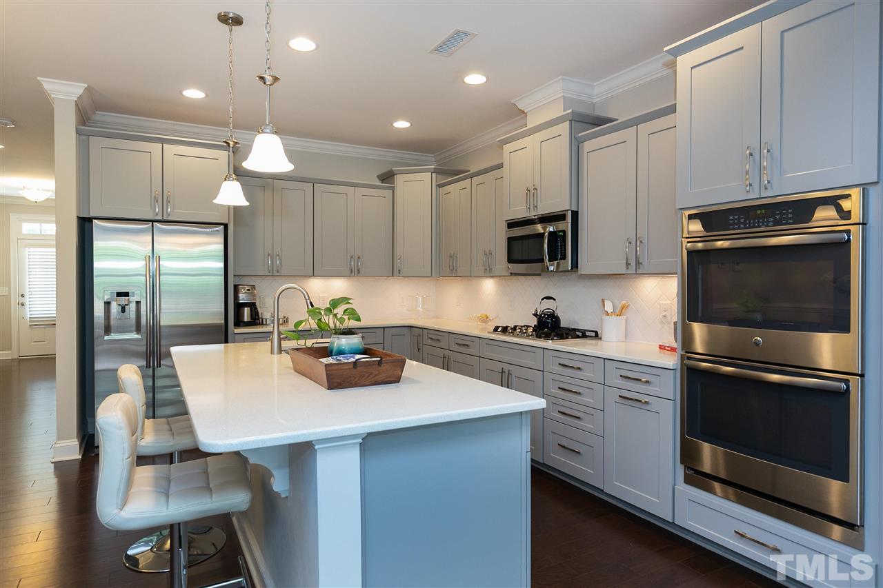 637 Fallon Grove Way Raleigh, NC 27608 - Photo 10 of 30 a kitchen with a stove a microwave a dining table and chairs