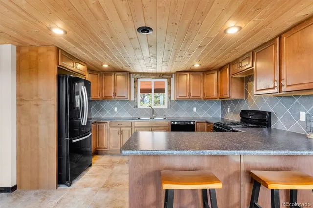 a kitchen with stainless steel appliances granite countertop a stove refrigerator sink and cabinets
