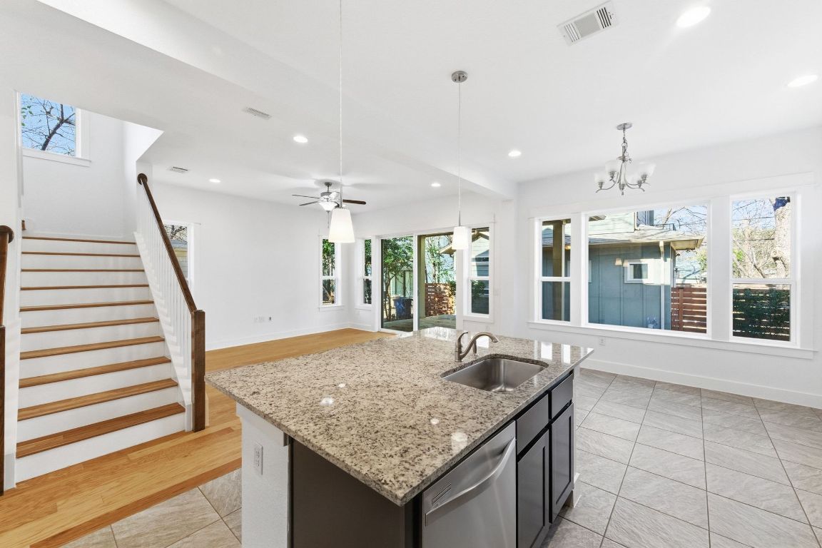 1912 Haskell Street, Unit 1 Austin, TX 78702 - Photo 10 of 23 Kitchen with a center island with sink, stainless steel dishwasher, recessed lighting, hanging light fixtures, and light stone counters