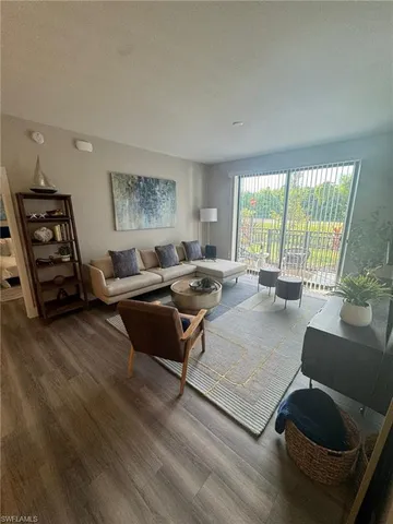 a living room with furniture and a floor to ceiling window