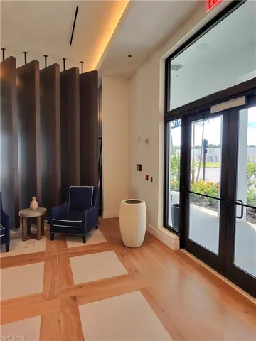 a living room with patio furniture and a potted plant