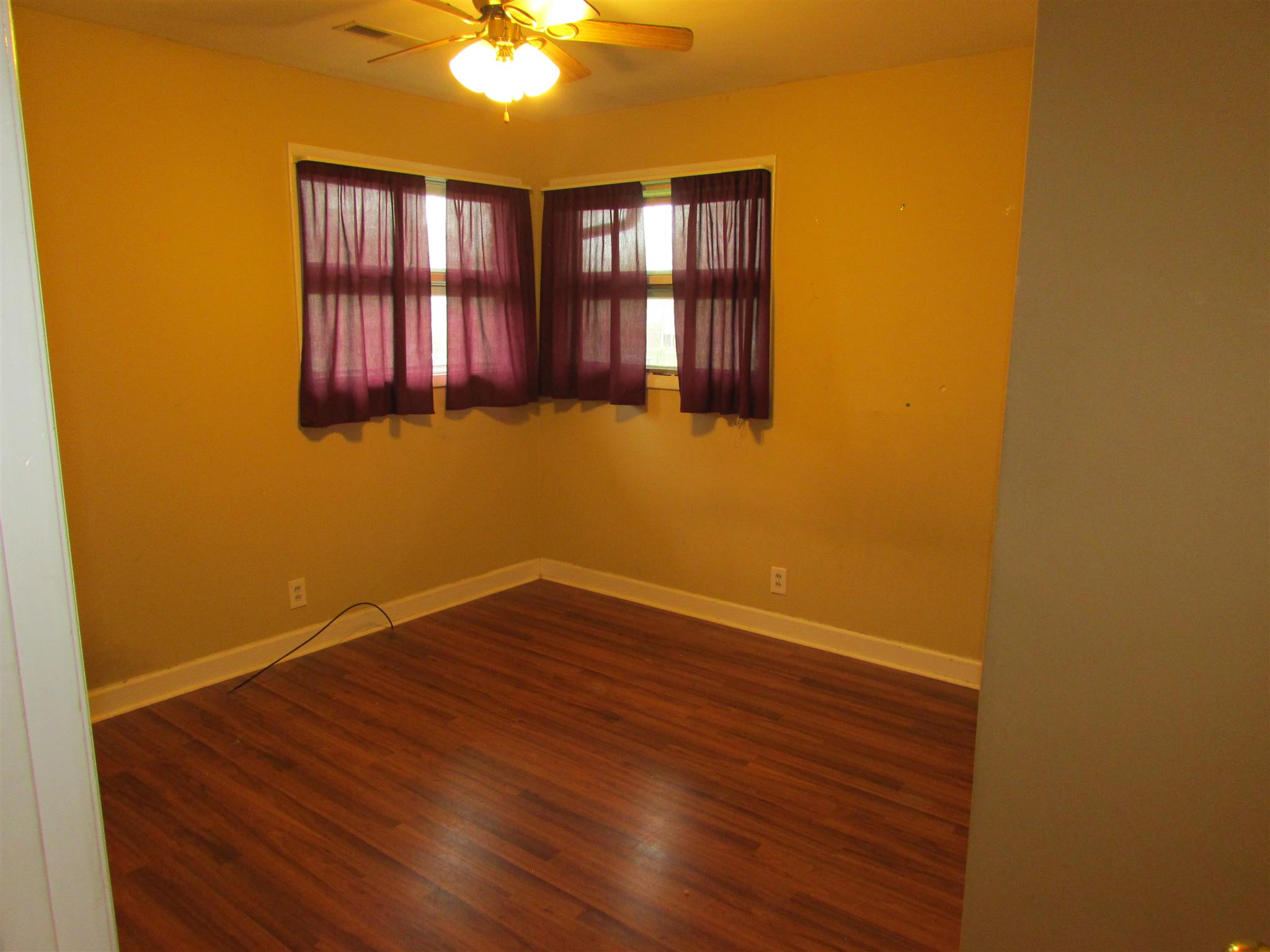 1704 3rd Avenue Manchester, TN 37355 - Photo 14 of 19 a view of an empty room with wooden floor and a window