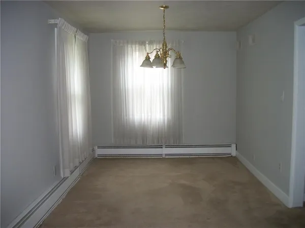 en empty room with windows and chandelier fan