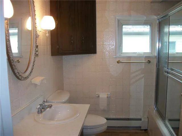 a bathroom with a toilet sink and mirror